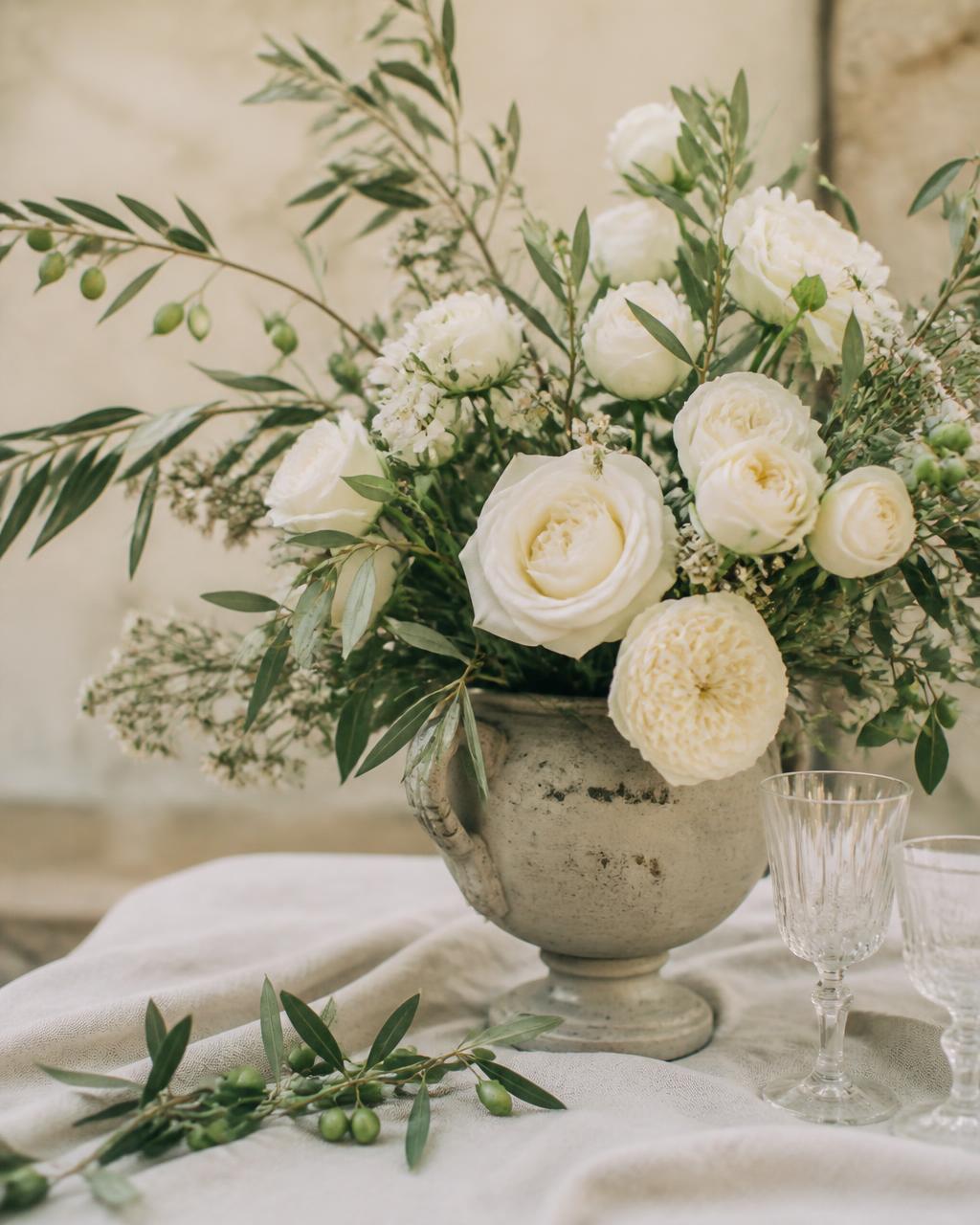 Placeholder: white roses and olive branches in a stone urn